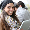 Female student wearing a black beanie holding a tablet
