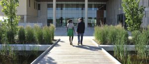 Man and woman walking across boardwalk towards Orillia campus building