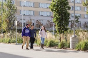 Three students walking on LU campus grounds
