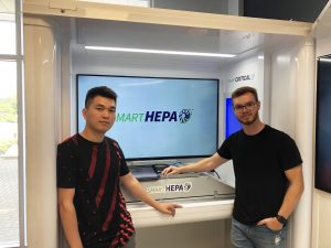Two computer science students standing with smart HEPA booth