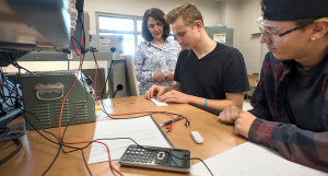 Two students work alongside a faculty instructor in the electrical engineering lab at Georgian College